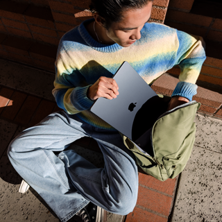 Una persona che ripone un MacBook Air da 15 pollici in una borsa