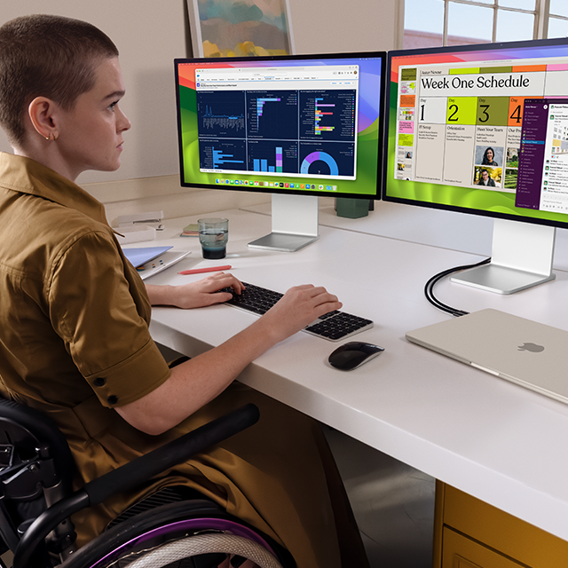 Una persona che lavora a due monitor esterni collegati a un MacBook Air da 15 pollici chiuso color galassia