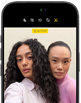 iPhone 18 Pro nero mostrato di fronte, sul display due persone in posa davanti alla fotocamera frontale Center Stage